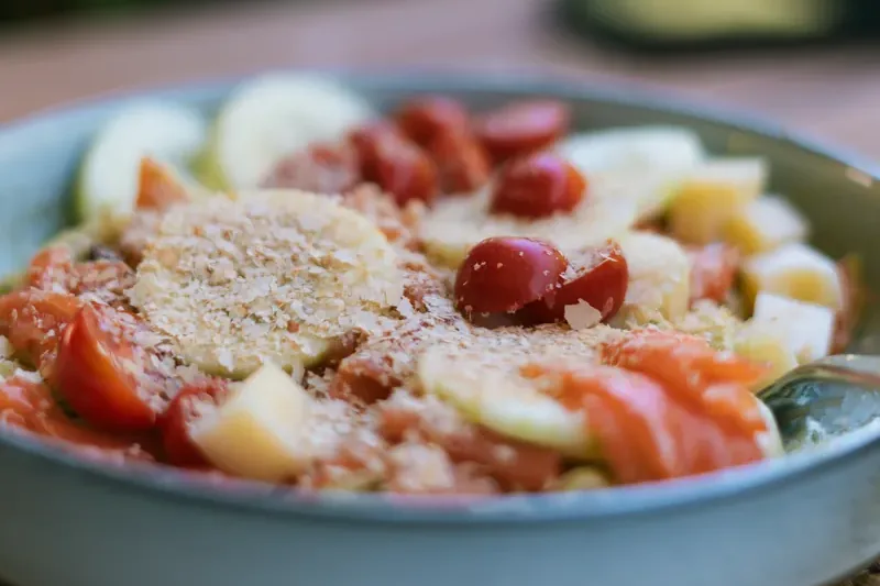 Bol de salade au saumon fumé, tomates cerises, concombre et fromage