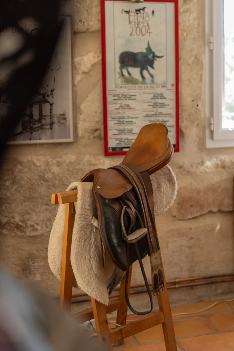 Selle de cheval sur tréteau devant une affiche de féria, maison Orpi Belle Pierre à Beaucaire