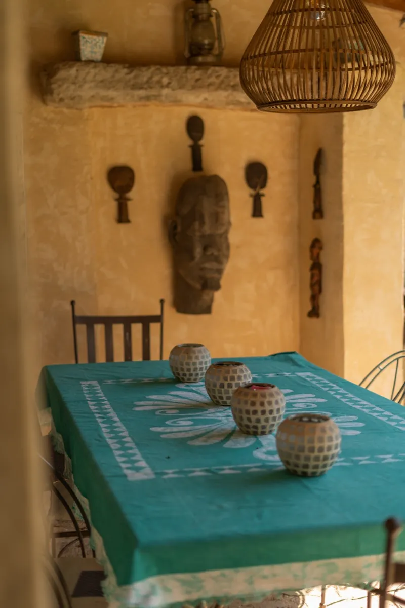 Table dressée avec bougeoirs et masques africains muraux, maison Orpi Belle Pierre à Beaucaire