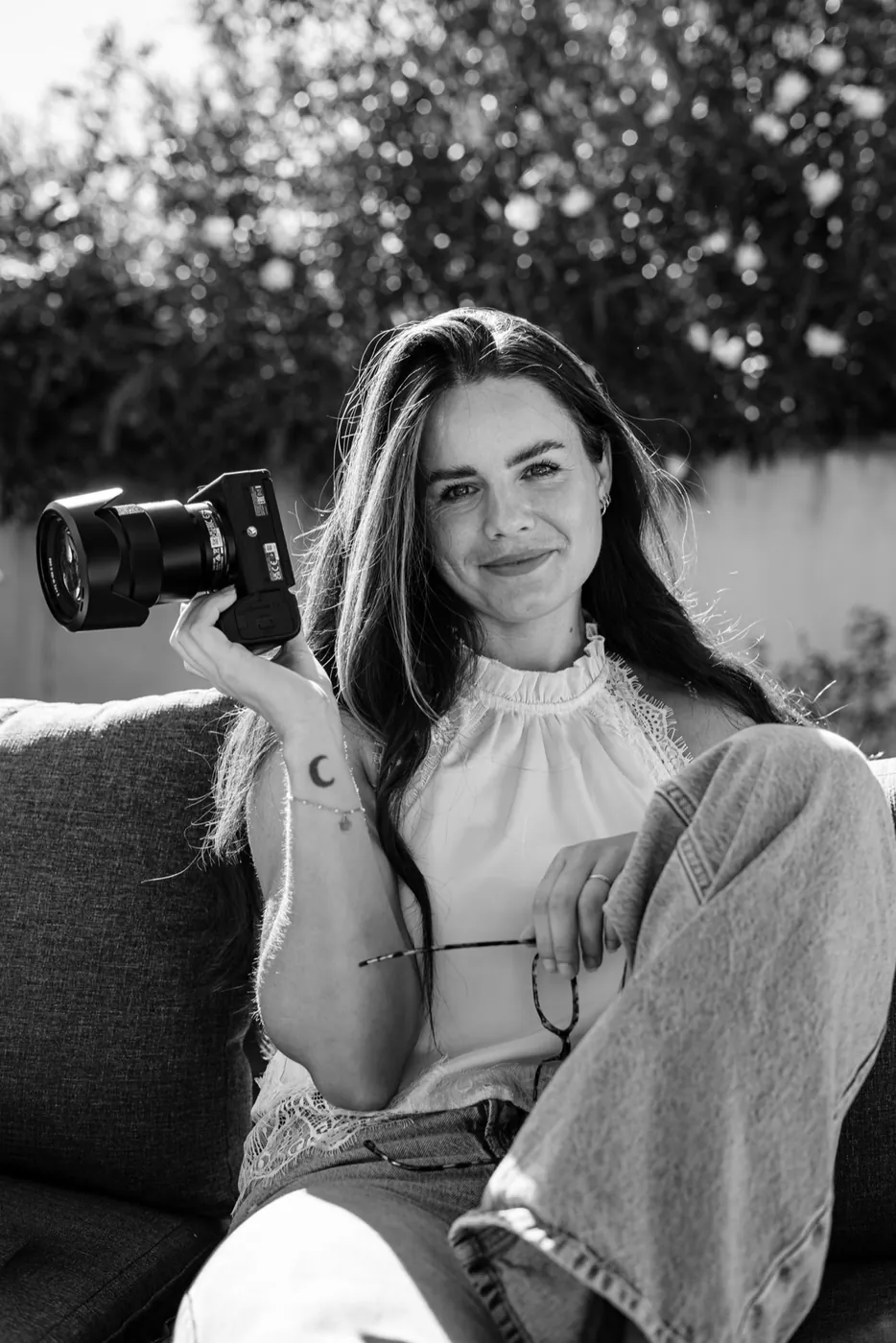 Portrait en noir et blanc de Tessa Godin avec son appareil photo